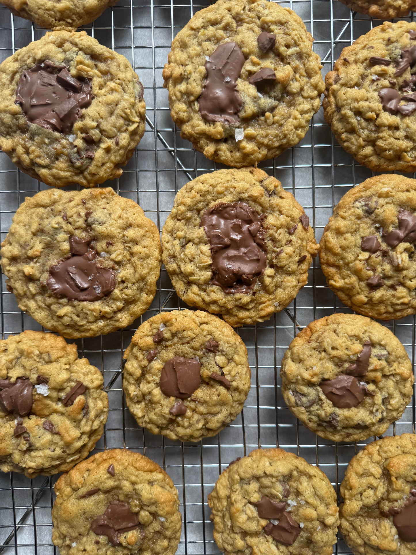 Oatmeal cookies with chocolate chunks on a cooling rack